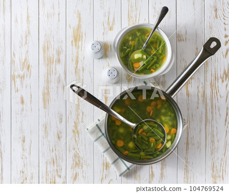 vegetarian dish, dietary delicious soup of green beans on a white wooden table, top view. vegetarian dish, dietary delicious soup of green beans on a white wooden table, top view. 104769524