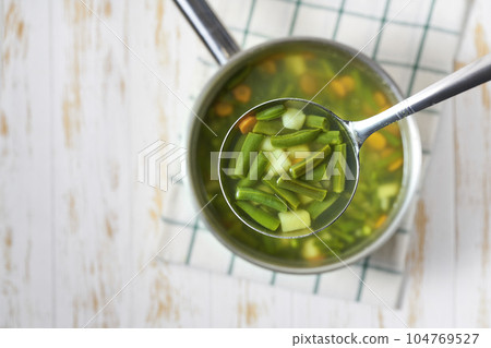 Green soup with potato, green bean and carrot , top view. Selective focus. 104769527