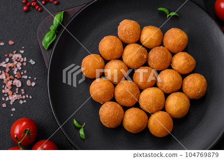 Delicious fried potato balls with breaded mozzarella, salt, spices and herbs Delicious fried potato balls with breaded mozzarella, salt, spices and herbs 104769879