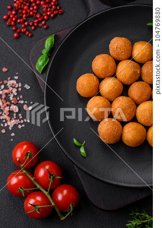 Delicious fried potato balls with breaded mozzarella, salt, spices and herbs 104769880