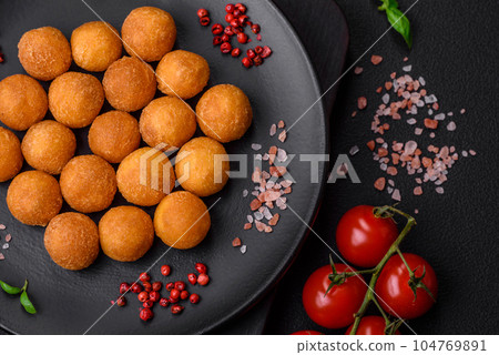 Delicious fried potato balls with breaded mozzarella, salt, spices and herbs 104769891