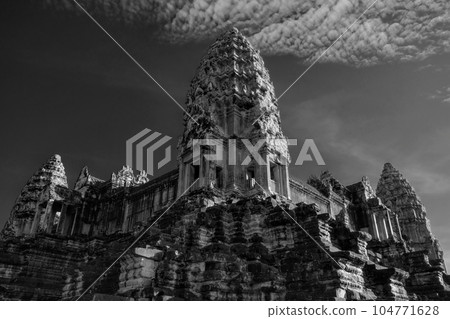 The tall decorated stone tower of the Khmer temple of Angkor Wat in Cambodia under a clear sky. 104771628