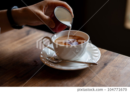 將牛奶倒入一杯白茶中 104771670