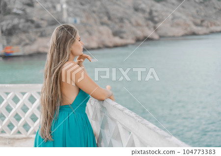 Woman sea green dress. Side view a happy woman with long hair in a long mint dress posing on a beach with calm sea bokeh lights on sunny day. Girl on the nature on blue sky background. Woman sea green dress. Side view a happy woman with long hair in a long mint dress posing on a beach with calm sea bokeh lights on sunny day. Girl on the nature on blue sky background. 104773383