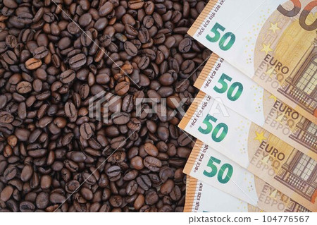The 50 euro bills are on roasted coffee beans. The concept of rising food prices, the global food crisis. The 50 euro bills are on roasted coffee beans. The concept of rising food prices, the global food crisis. 104776567