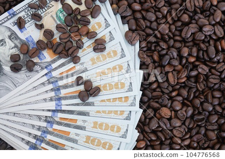 The 100 dollar bills are on roasted coffee beans. The concept of rising food prices, the global food crisis. 104776568