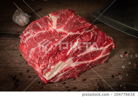 Raw beef steak with spices on a dark slate, stone or concrete background. Top view with copy space. Raw beef steak with spices on a dark slate, stone or concrete background. Top view with copy space. 104776638