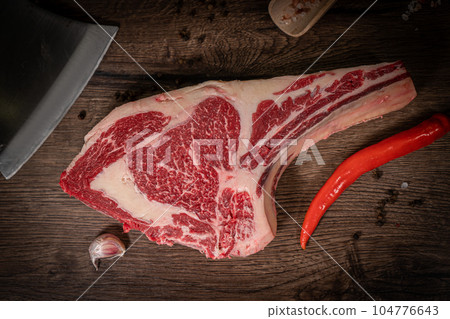 Raw beef steak with spices on a dark slate, stone or concrete background. Top view with copy space. Raw beef steak with spices on a dark slate, stone or concrete background. Top view with copy space. 104776643