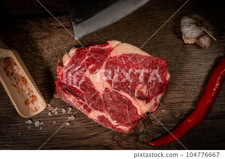 Organic machete or hanger butcher steak, near butcher knife with pink pepper and rosemary. Black background. Top view. side view 104776667