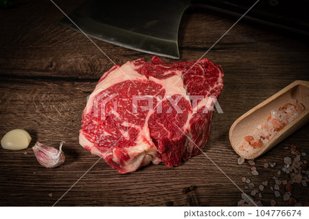 Organic machete or hanger butcher steak, near butcher knife with pink pepper and rosemary. Black background. Top view. side view 104776674
