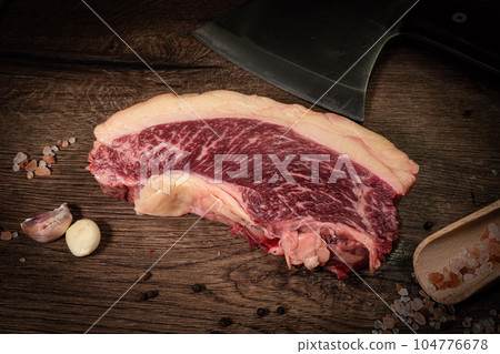 Organic machete or hanger butcher steak, near butcher knife with pink pepper and rosemary. Black background. Top view. side view 104776678