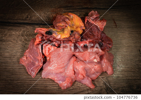 raw cow beef parts on wooden background. Fresh beef parts for sale. Food for dog 104776736