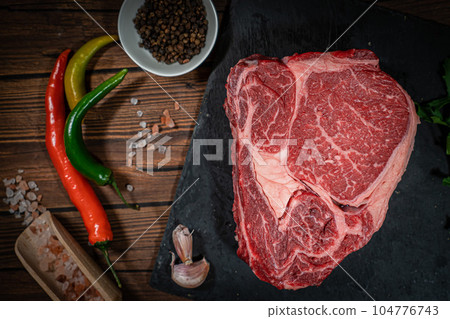 Variety of Fresh Raw Black Angus Prime Meat Steaks New York, Ribeye and seasoning on wooden background, top view 104776743