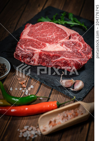 Variety of Fresh Raw Black Angus Prime Meat Steaks New York, Ribeye and seasoning on wooden background, top view Variety of Fresh Raw Black Angus Prime Meat Steaks New York, Ribeye and seasoning on wooden background, top view 104776745