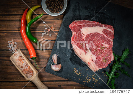 Variety of Fresh Raw Black Angus Prime Meat Steaks New York, Ribeye and seasoning on wooden background, top view Variety of Fresh Raw Black Angus Prime Meat Steaks New York, Ribeye and seasoning on wooden background, top view 104776747