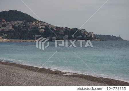 Morning waves on pebble beach in Nice, France Morning waves on pebble beach in Nice, France 104778535
