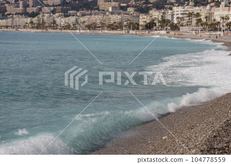 Morning waves on pebble beach in Nice, France 104778559