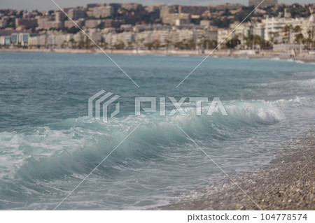 Morning waves on pebble beach in Nice, France 104778574