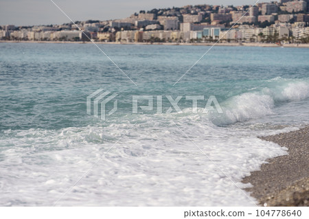 Morning waves on pebble beach in Nice, France Morning waves on pebble beach in Nice, France 104778640