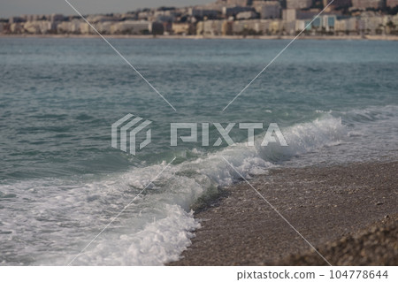 Morning waves on pebble beach in Nice, France Morning waves on pebble beach in Nice, France 104778644
