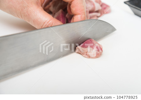 [Housewife preparing yakitori pork tongue with a knife] 104778925
