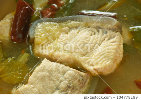 spicy boiled Maekong giant catfish with herb and chili tom yum soup on bowl 104779189