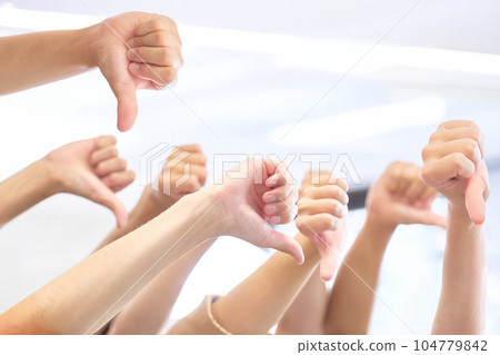 many hands giving thumbs down 104779842
