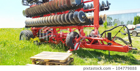 Large disc plough, towing for tractors to plow fields 104779888
