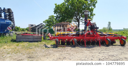 The colorful red seeder on the ground The colorful red seeder on the ground 104779895