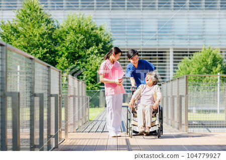 Senior women in wheelchairs and young care staff 104779927