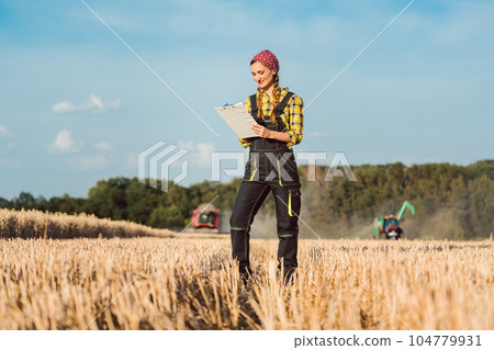 Farmer woman monitoring business progress of the harvest Farmer woman monitoring business progress of the harvest 104779931