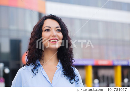Happy business woman in a blue shirt in a cityscape Happy business woman in a blue shirt in a cityscape 104781057