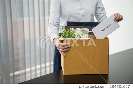 Business woman sending resignation letter and packing Stuff Resign Depress or carrying business cardboard box by desk in office. Change of job or fired from company. Business woman sending resignation letter and packing Stuff Resign Depress or carrying business cardboard box by desk in office. Change of job or fired from company. 104781667