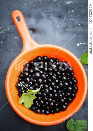 Blackberry in a sieve on a dark background Blackberry in a sieve on a dark background 104782099