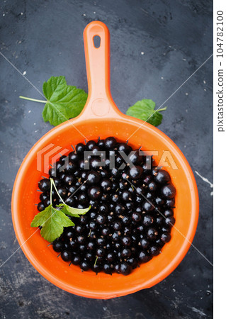 Blackberry in an orange sieve on a dark Blackberry in an orange sieve on a dark 104782100