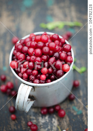 cranberry in vintage metal cup on dark background cranberry in vintage metal cup on dark background 104782128