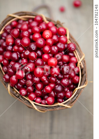 berry cranberries in a wooden basket on a wooden background 104782148