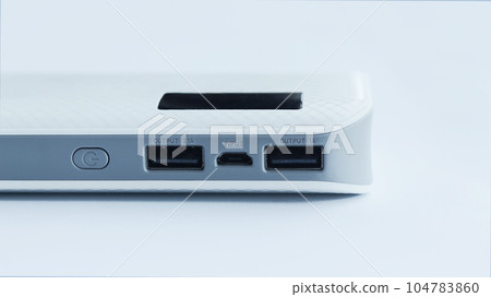 A white flat power bank isolated on white background with two usb output and one input socket electrical source. 104783860