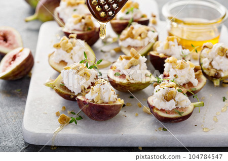 Fresh figs stuffed with ricotta and pine nuts 104784547