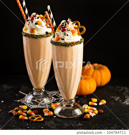 Halloween pumpkin milkshake decorated with candy Halloween pumpkin milkshake decorated with candy 104784711