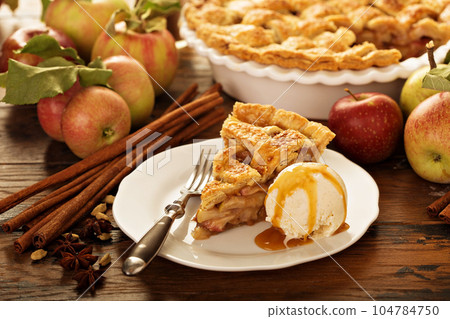 Piece of an apple pie with ice cream on a plate 104784750