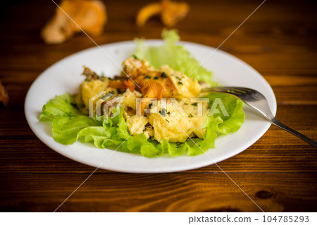 fried omelet with forest mushrooms chanterelles, on table 104785293