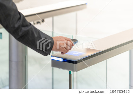 Businessman touching the entrance card of the office at the entrance (commuting / going to work) Businessman touching the entrance card of the office at the entrance (commuting / going to work) 104785435