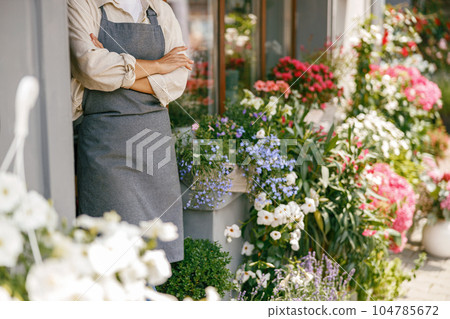 Close up of woman florist small business owner standing with crossed arms in own floral store 104785672