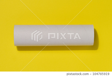 White paper towel from a roll of kitchen towels, object on a yellow background, top view 104785919