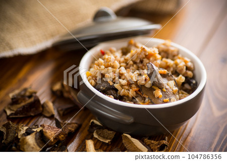 boiled buckwheat with organic forest dried mushrooms in a ceramic bowl 104786356