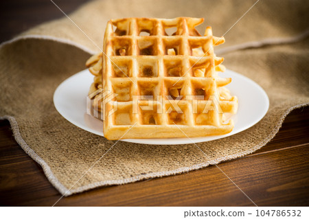 sweet cooked aromatic Belgian waffles in a plate 104786532