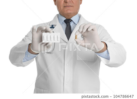 Doctor holding suppositories for hemorrhoid treatment on white background, closeup 104786647
