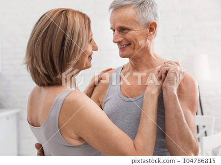 Happy senior couple dancing together at home Happy senior couple dancing together at home 104786815