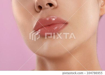 Young woman with beautiful full lips on pink background, closeup 104786955